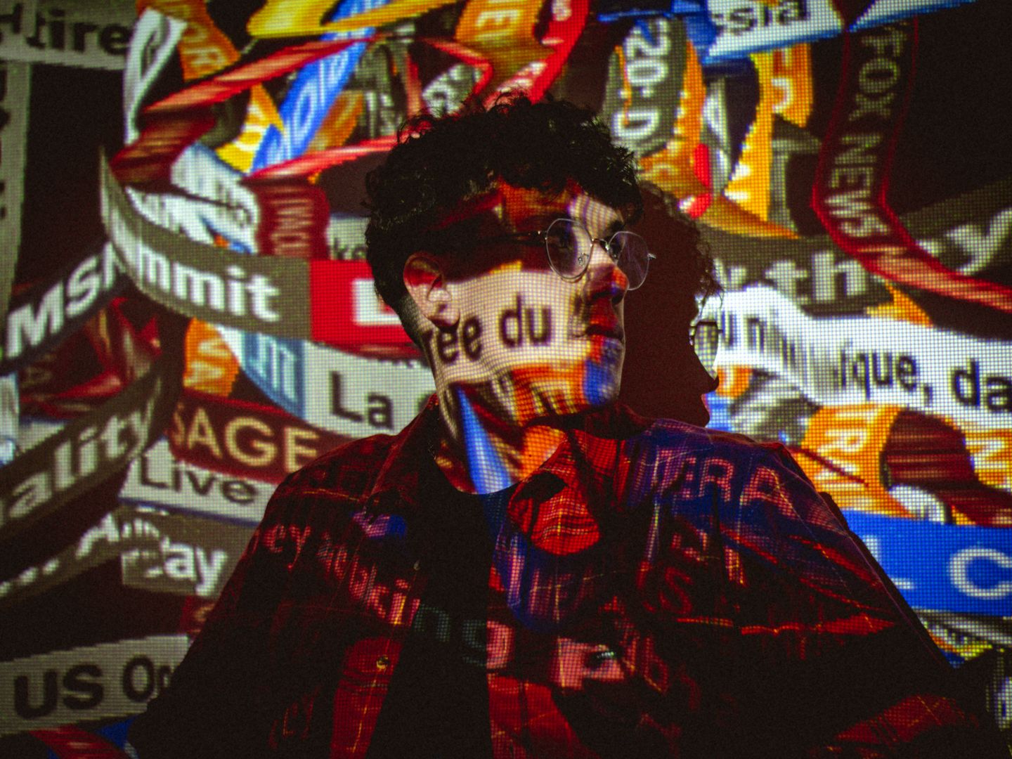 Conceptual photo of a person with news ticker projections on their face and body.